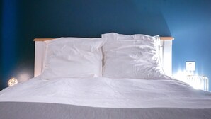 A neatly made bed with white linens in a room with dark blue walls. - Urban Calm - Bright & Modern Stay (Le Mans)