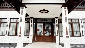 A building with a symmetrical facade, large windows, and a central entrance with a roof overhang. - Vidra Dacica (Vidra)