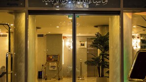 A hotel entrance with a chandelier, glass doors, and a marble floor. - Salmiya Grand Hotel (Salmiya)