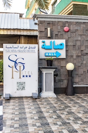 A hotel entrance with a sign for 'Salmiyya Grand Hotel' and a directional sign for 'Hall'. - Salmiya Grand Hotel (Salmiya)