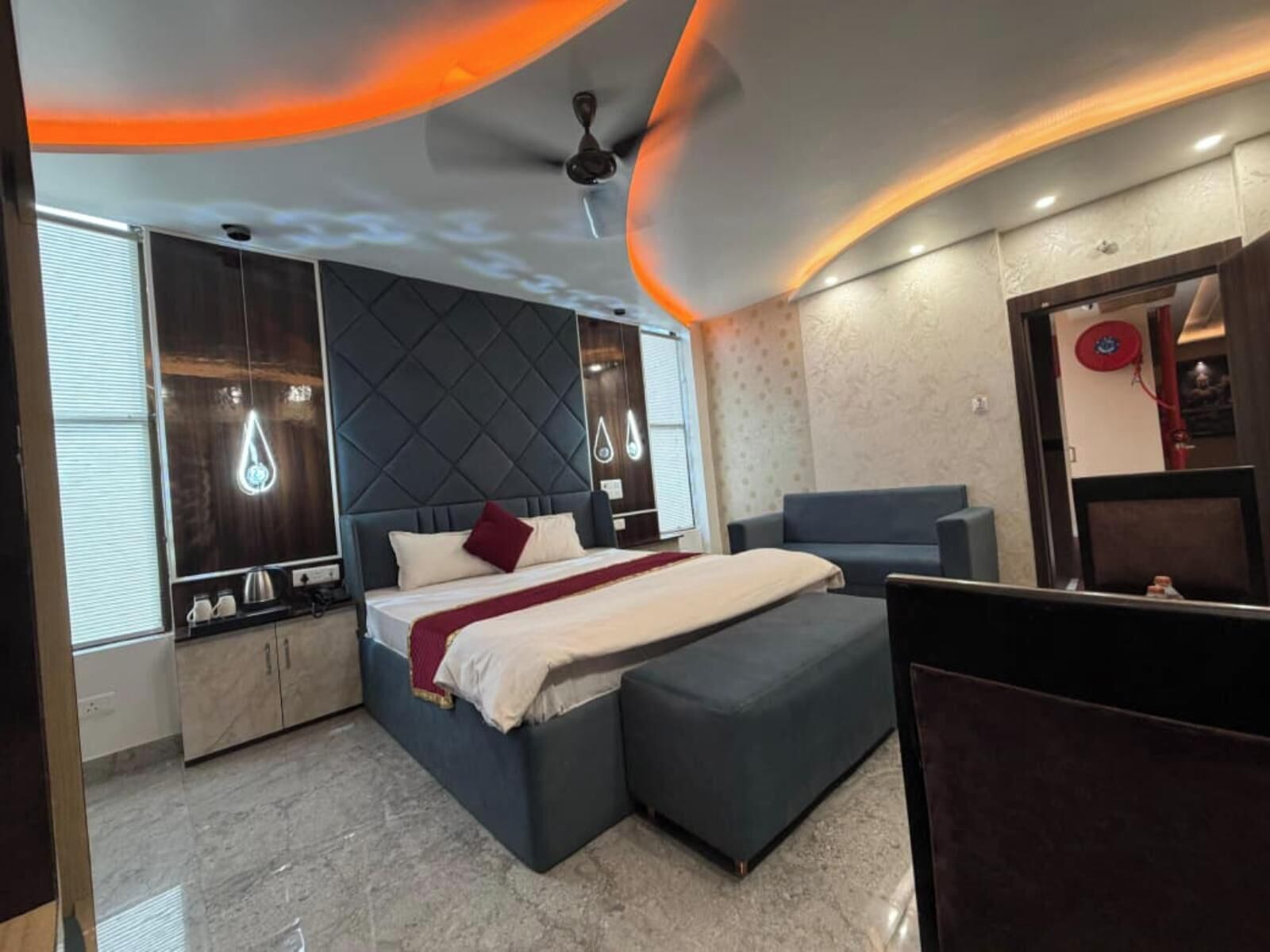 A modern bedroom with a bed, a sofa, and a small table.