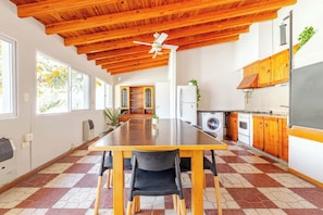 A spacious kitchen with wooden cabinets, a large island, and a ceiling fan.