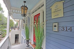 A porch with a red door, a number 314 sign, and a lamp post.