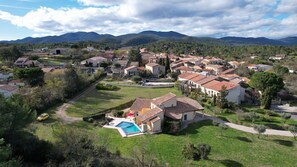 A residential area with houses, a swimming pool, and mountains in the background. - Villa in France With Private Pool & Garden (Prades-sur-Vernazobre)