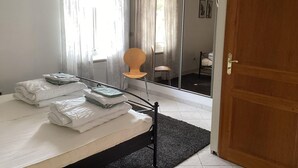 A bedroom with a bed, a chair, a mirror, and a door. - Villa in France With Private Pool & Garden (Prades-sur-Vernazobre)