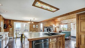 Una cocina amplia con muebles de madera, una isla central con fregadero y un lavavajillas integrado.