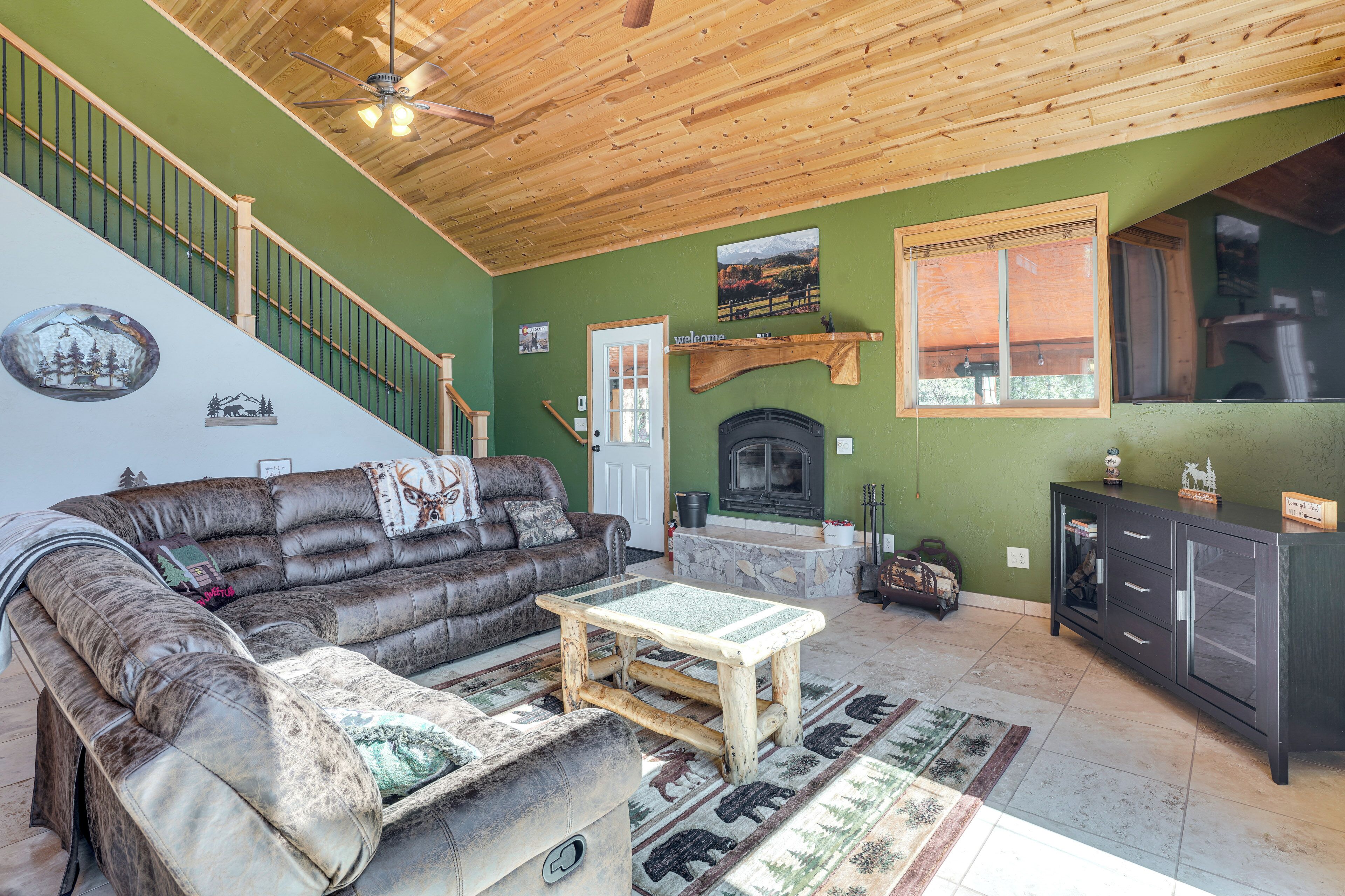 A living room with a brown leather sofa, a wooden coffee table, and a fireplace.