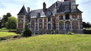 A large, historic building with multiple towers and a prominent clock tower. - Elegant Chateau Escape for 2 - Nature & Calm (Nointot)