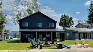 A house with a deck, outdoor seating, and a swimming pool.