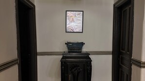 A hallway with a black console table, a framed picture on the wall, and a hanging light fixture.