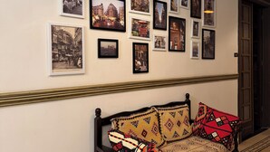 A hallway with a bench and a wall adorned with framed photographs.