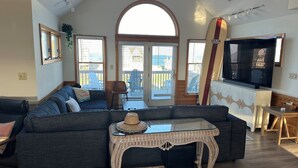 A living room with a sectional sofa, a glass-top coffee table, a television, and a large window with a view of the outside. - Welcome to Wreckless! Beautiful home with AC and WIFI in delightful Avon (Avon)