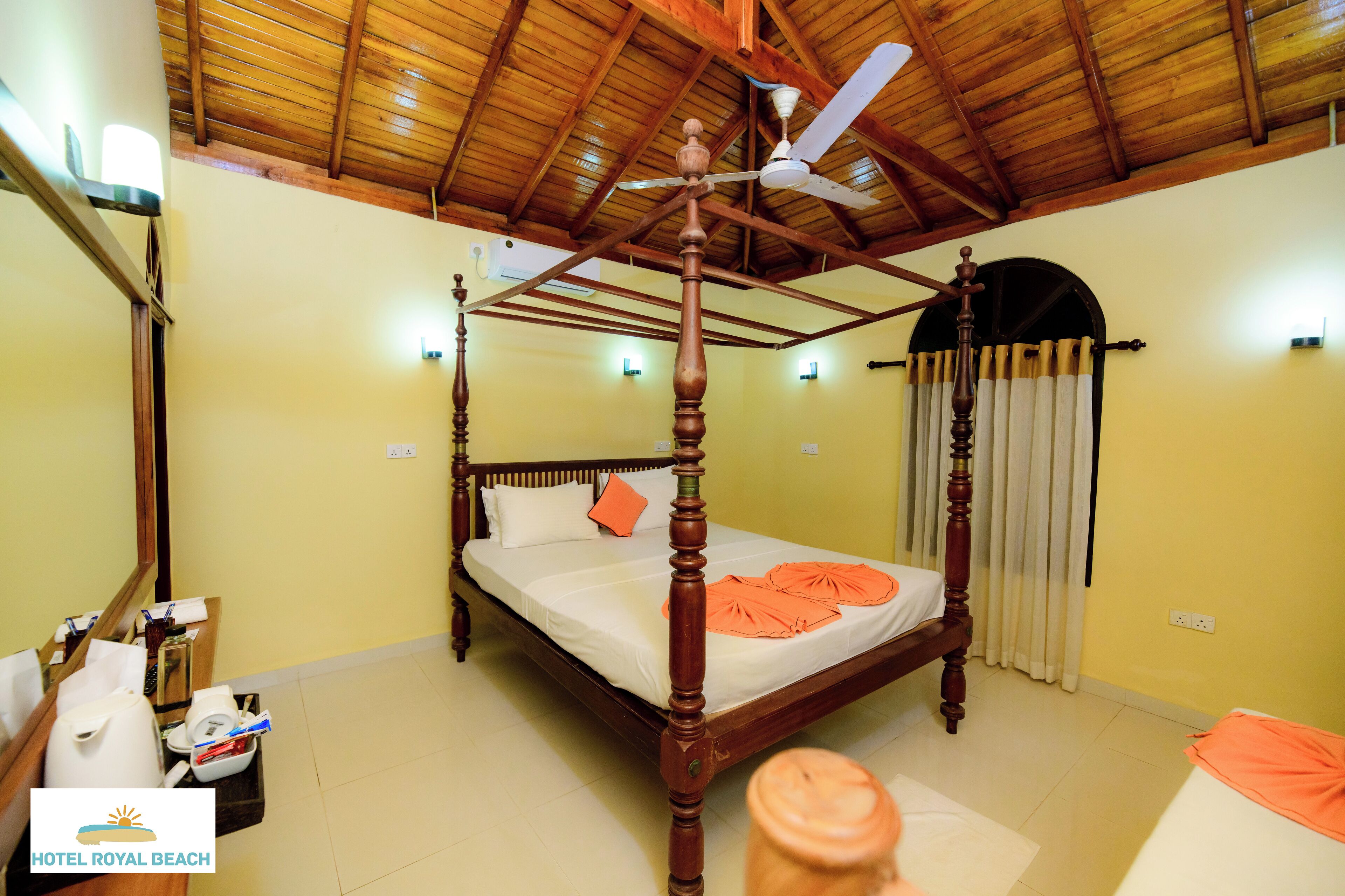 A four-poster bed with a wooden frame and a ceiling fan above.