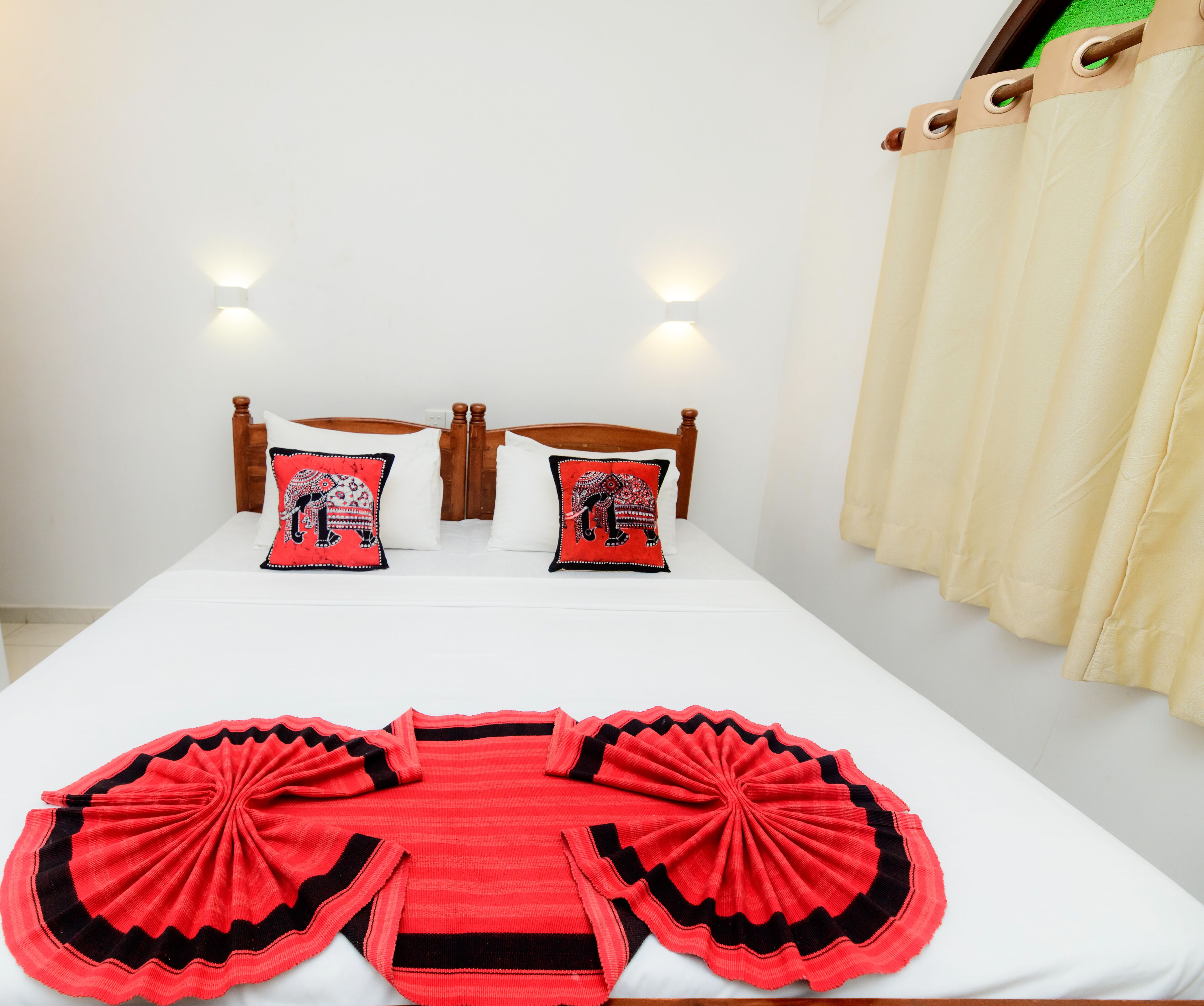 A bed with two pillows, a wooden headboard, and a white mattress.