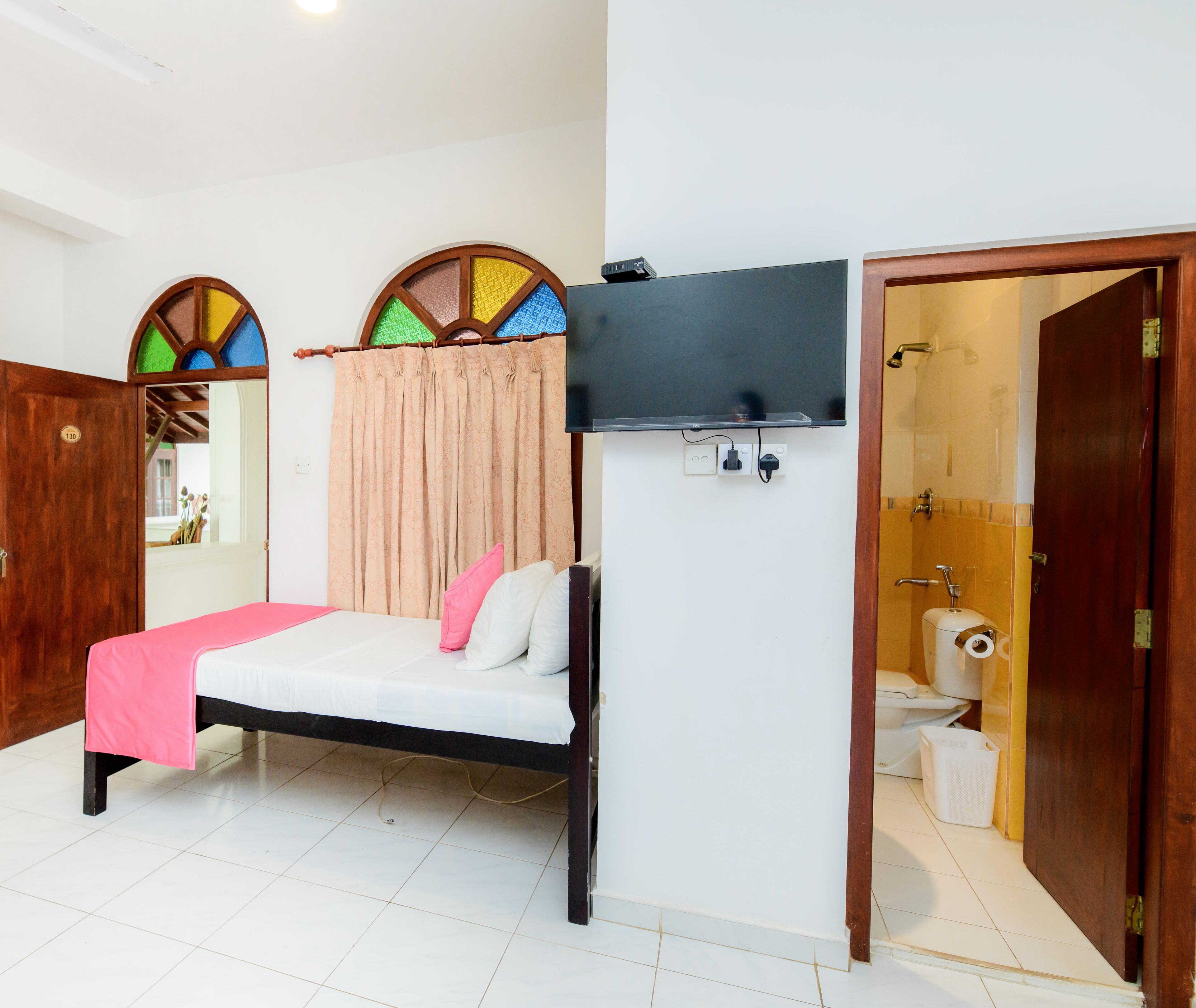 Una habitación con cama, televisión, ducha e inodoro.