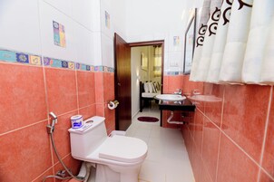 Un baño con inodoro, lavamanos y ducha.