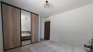 Ein Schlafzimmer mit einem Bett, einem Kleiderschrank und einer Tür.