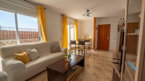 Uma sala de estar com sofá, mesa de centro e área de refeições.