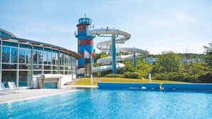 Una piscina con tobogán y una alta estructura tipo torre.