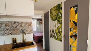 A kitchen with a wooden countertop, a gold faucet, and a patterned backsplash. - Seafront apartment with sea view. Everything within walking distance with parking lot. (Saint-Cyr-sur-Mer)