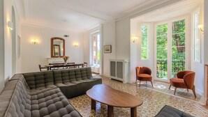 A spacious living room with a sectional sofa, a wooden coffee table, and a dining area with a table and chairs.