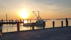 A pier with boats docked at sunset.