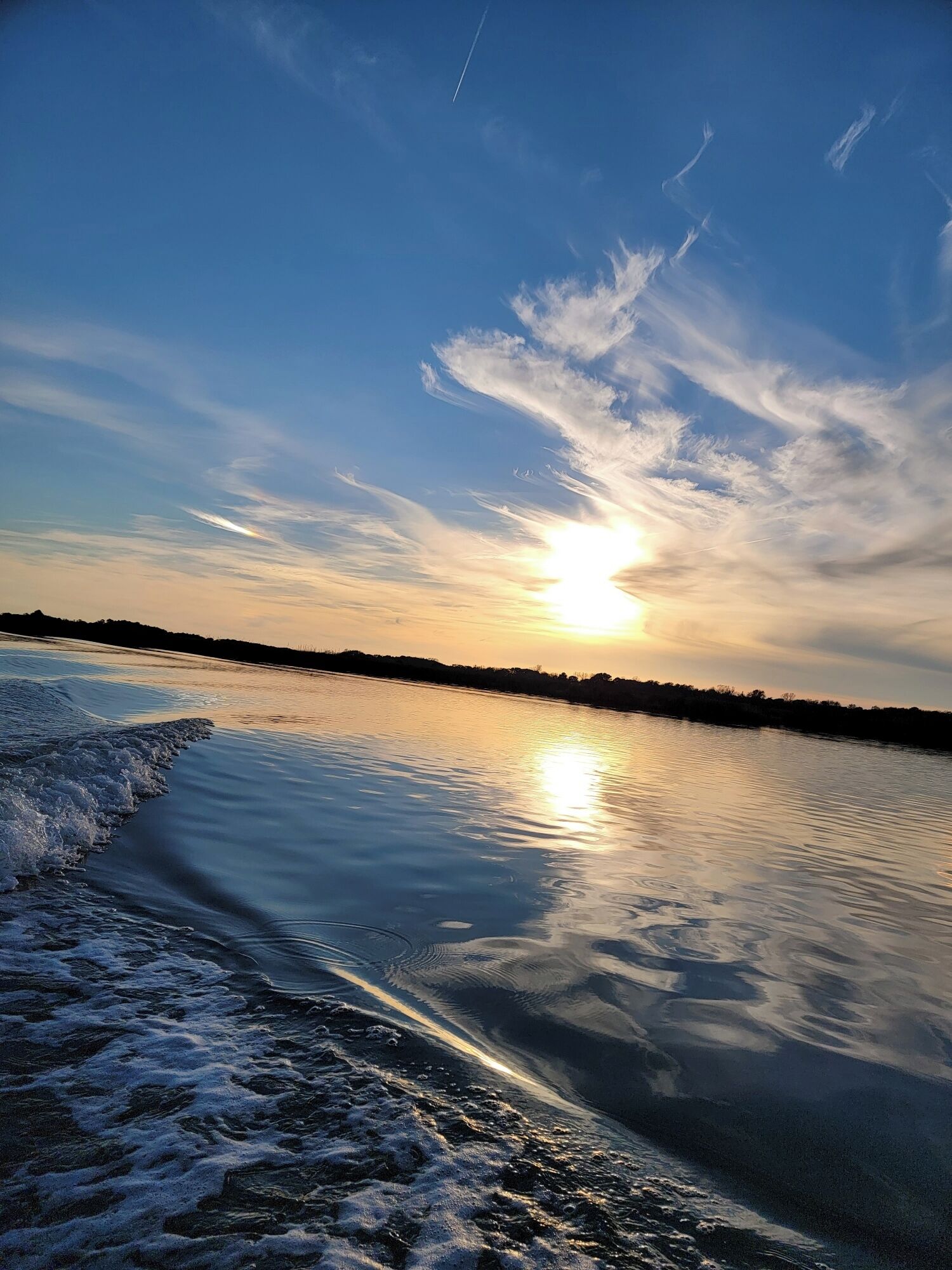 Stille vand, der spejler himlen i solnedgangen.