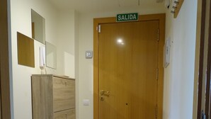A hallway with a wooden door labeled "SALIDA" and a white table with a metal frame.