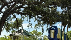 A playground with a slide and climbing structures, a gazebo, and a view of a body of water. - Best Resort in Naples, FL,Old Town,Ideal location 2BD/2BA,Property overlooks Bay (Naples)