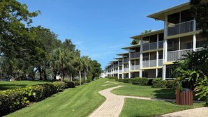 A pathway leading to a building with multiple balconies and a well-maintained lawn. - Best Resort in Naples, FL,Old Town,Ideal location 2BD/2BA,Property overlooks Bay (Naples)