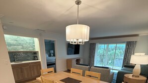 A modern dining area with a wooden table and chairs, a ceiling fan, and a view of the outdoors. - Best Resort in Naples, FL,Old Town,Ideal location 2BD/2BA,Property overlooks Bay (Naples)