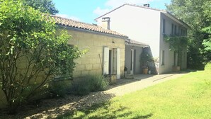 A two-story house with a tiled roof, a front door, and a small porch area.