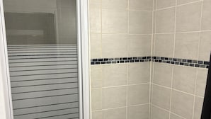 A bathroom with a toilet, a sink, and a shower area.