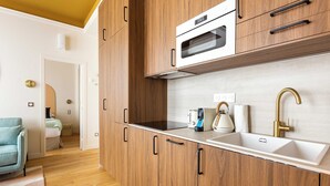 A modern kitchen with wooden cabinets, a built-in oven, and a stainless steel sink. - Port-royal Residence - Cosy Apartment - 1br- 4P (Paris)