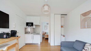 A modern kitchen with white cabinets, a microwave, and a coffee maker on the counter. - Charming Apartment - 1br-4p- Suresnes (Suresnes)