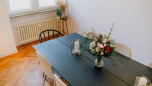 A dining table with chairs, a vase of flowers, and a candle. - Modern Apartment in Koblenz (Koblenz)