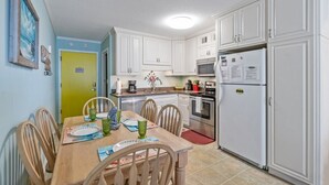 A kitchen with white cabinets, a refrigerator, a microwave, and a stove. - Finestere in Cherry Grove, 
Ocean view, 2 BR condo with direct beach access (Cherry Grove beach)