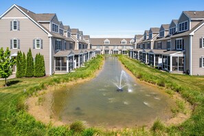 Una hilera de casas modernas con un elemento acuático central.