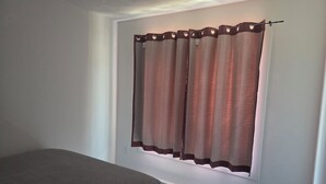 A bedroom with a bed, a window with curtains, and a radiator. - A Gorgeous 1bedroom Walkout Basement in a Serene Environment (Halifax)