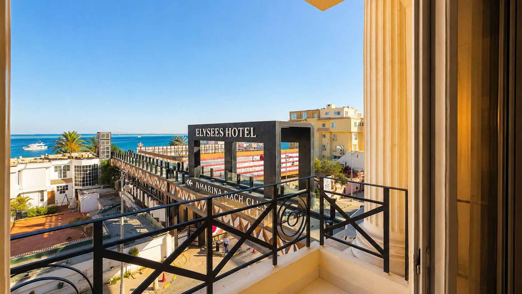 Un balcón con vista al mar y un cartel para el Hotel Elysées.