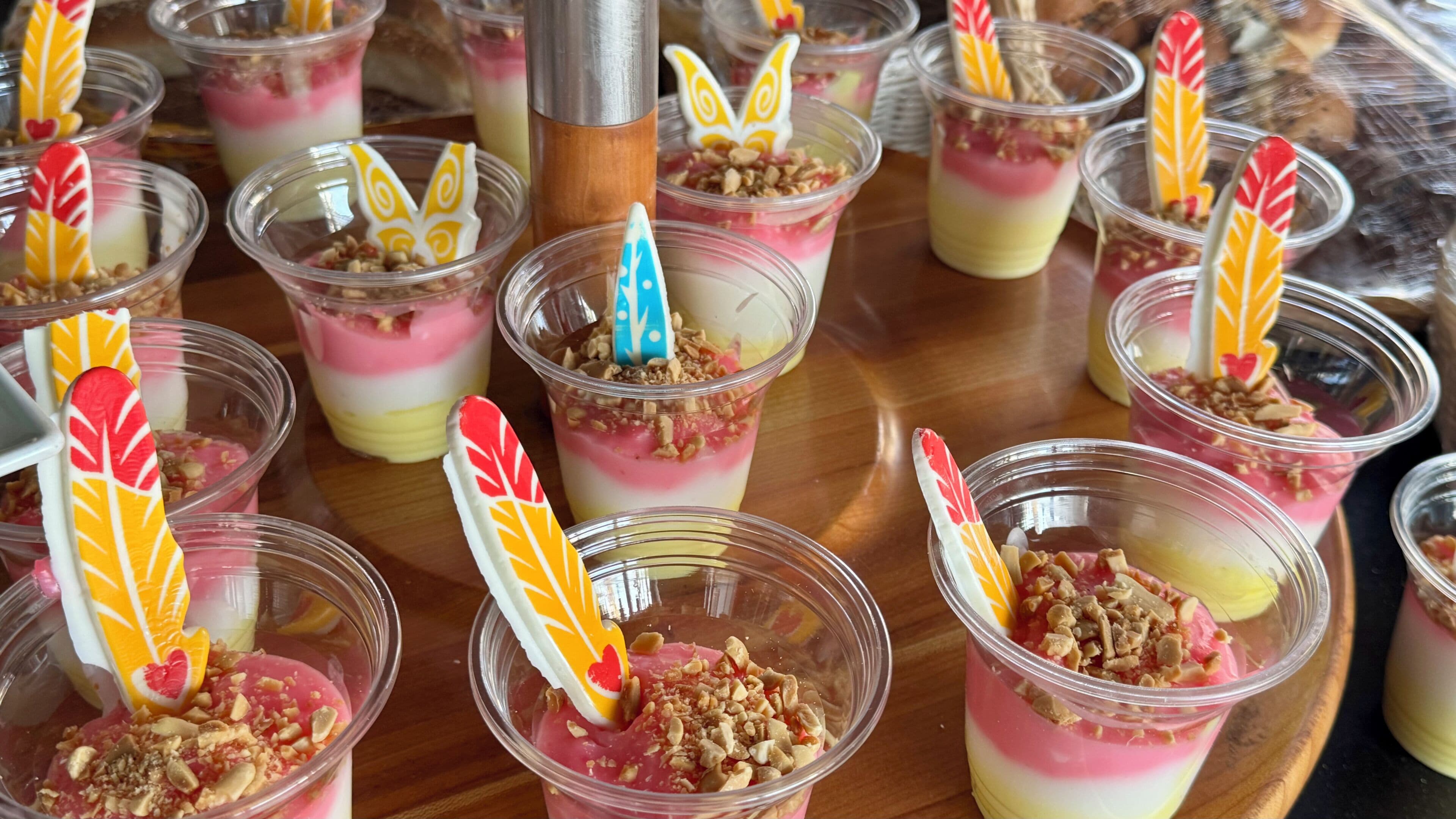 A tray of layered desserts with decorative spoons.
