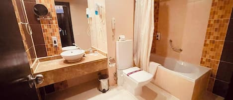 A bathroom with a sink, toilet, and bathtub, featuring a tiled wall and a mirror.