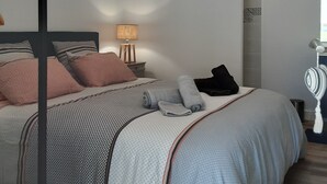 Een moderne slaapkamer met een bed, een bedlamp en een hangende lamp.