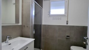 Ein Badezimmer mit Waschbecken, Toilette und Duschbereich.