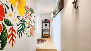 Eine Treppe mit hölzernem Geländer und einer Wand mit farbenfrohen floralen Bildern.