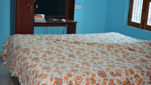 A bedroom with a bed, a television on a wooden stand, and a window with a view. - Charming 3-bedroom bungalow with AC, fitness room in wonderful Gwalior (GWALIOR)