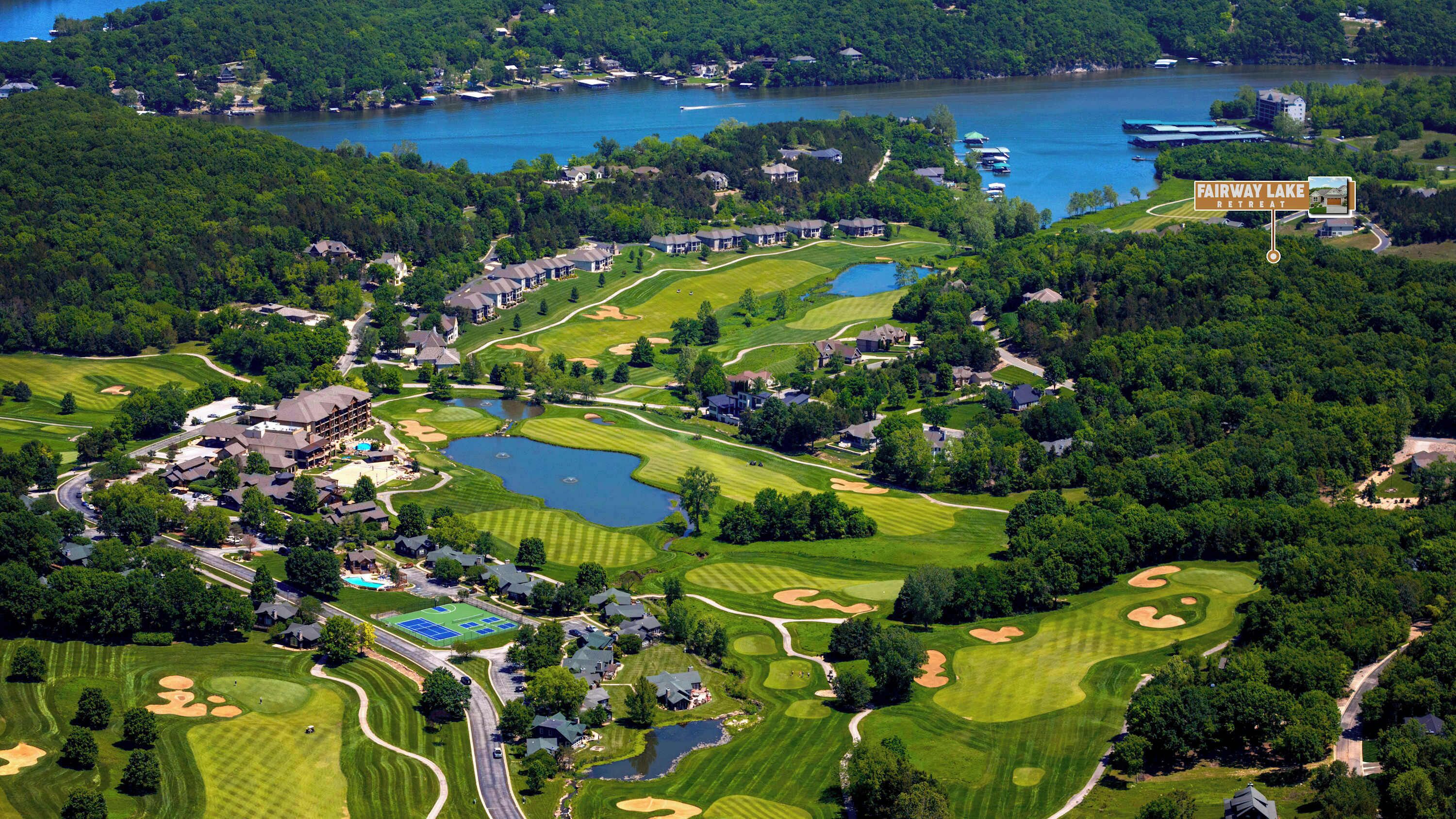 An aerial view of a golf course with multiple water hazards, a clubhouse, and a retreat center.