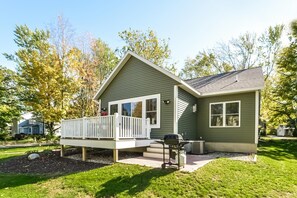 A single-story house with a front deck, a small porch, and a garage. - Four Generations (Saugatuck)