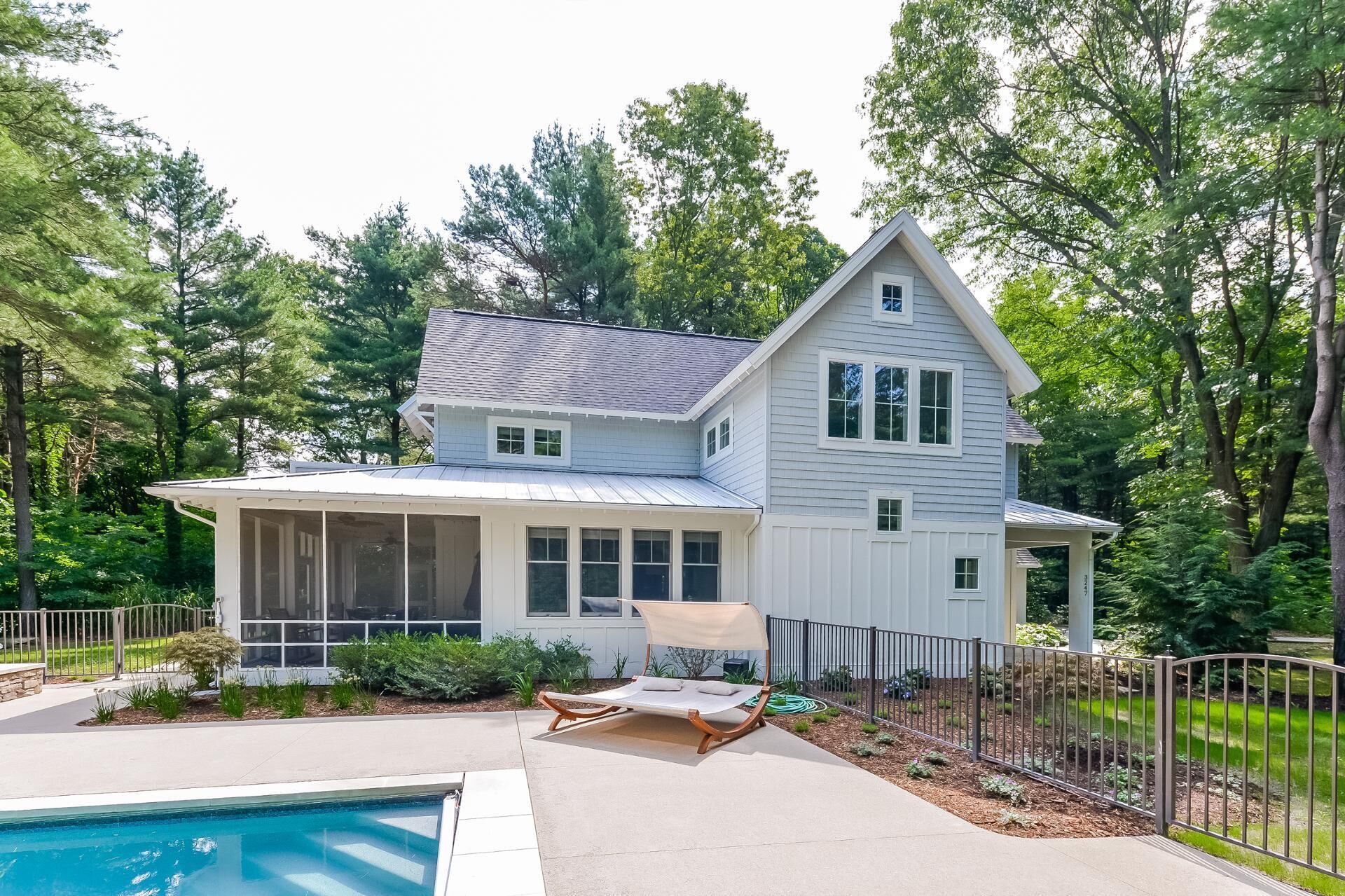Une maison à deux étages avec un patio couvert et une piscine.