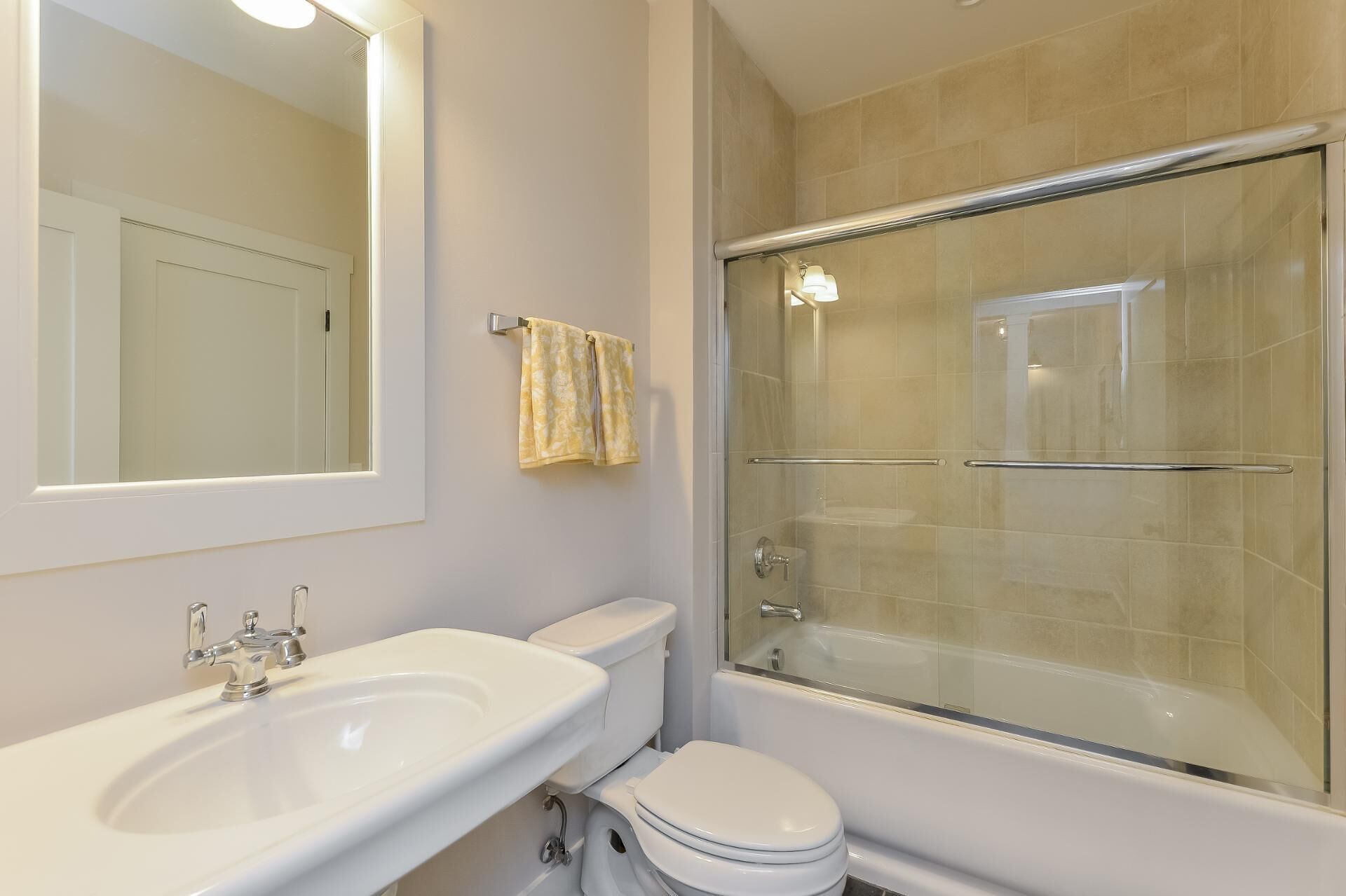 Een badkamer met een wit wastafelmeubel, toilet en douchecabine.